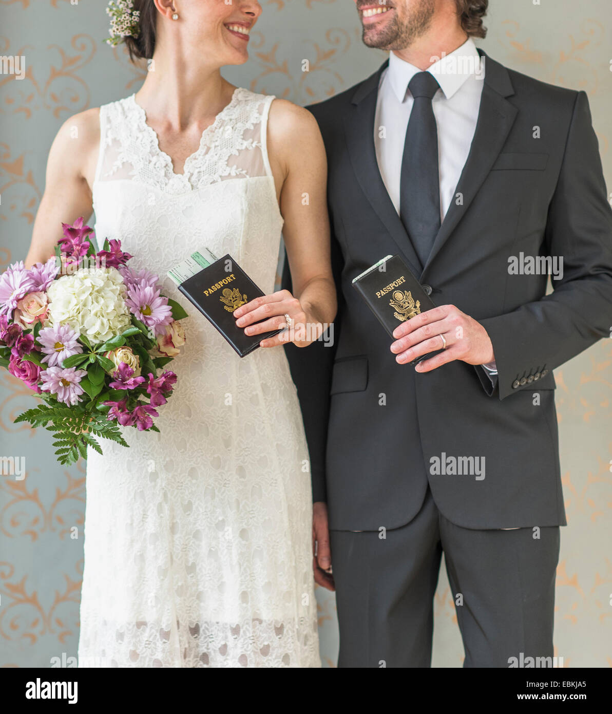 Happy bride and groom posing with passports Stock Photo
