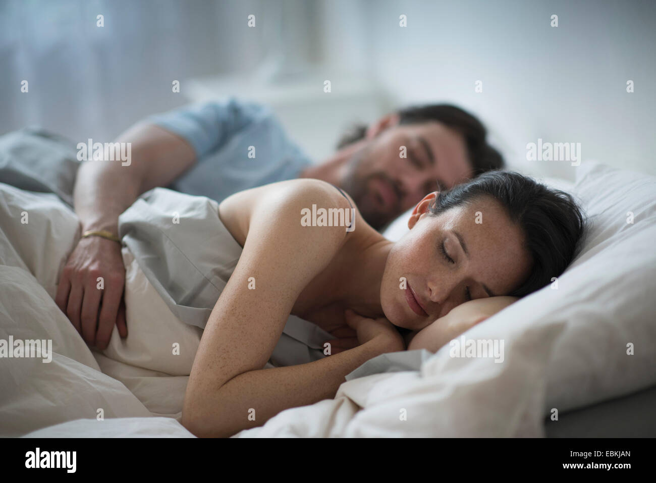 Couple sleeping together in bed at night Stock Photo