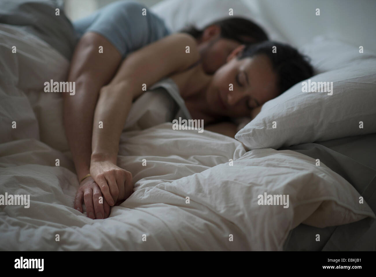 Couple sleeping together in bed at night Stock Photo