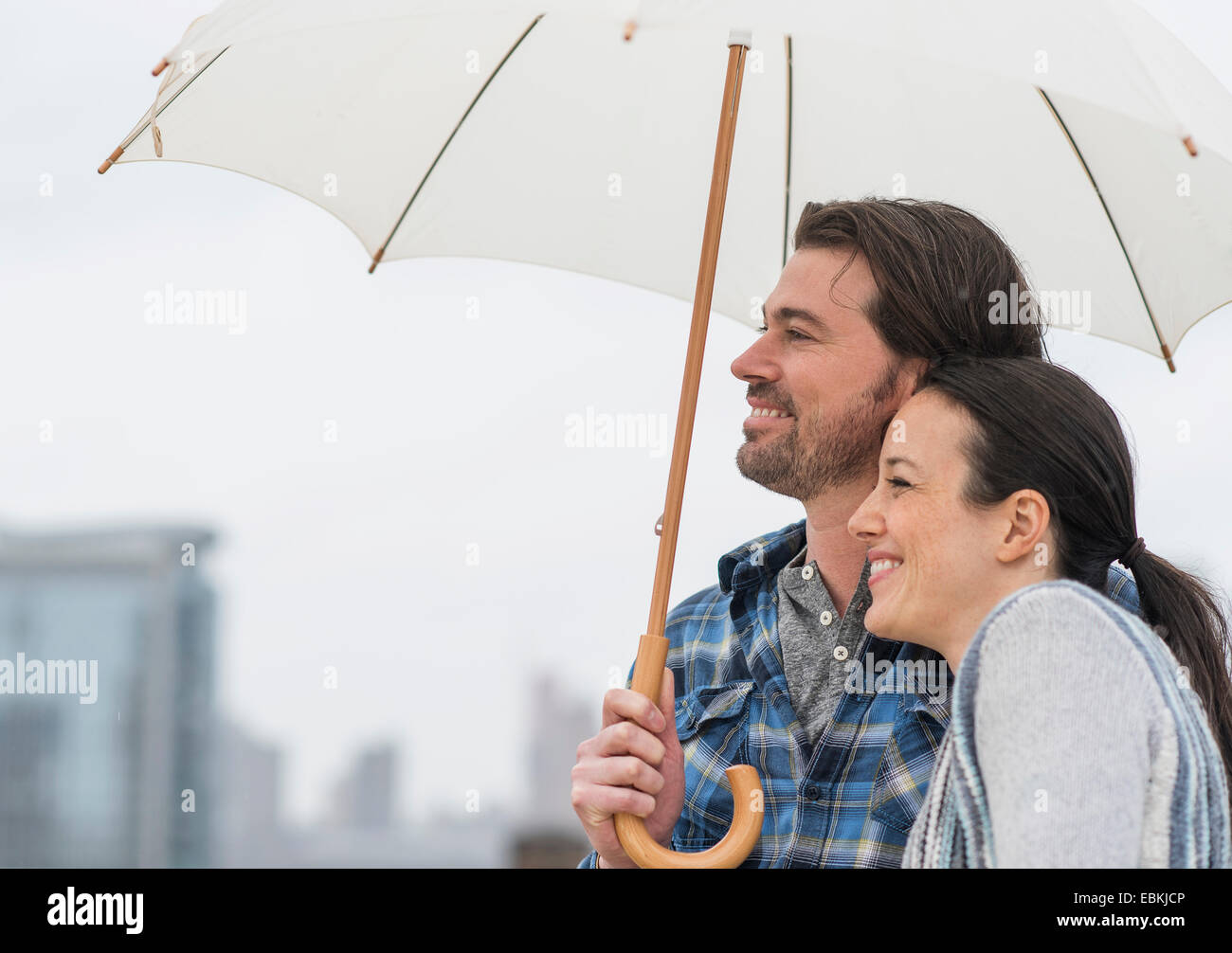 Side view of couple under umbrella Stock Photo