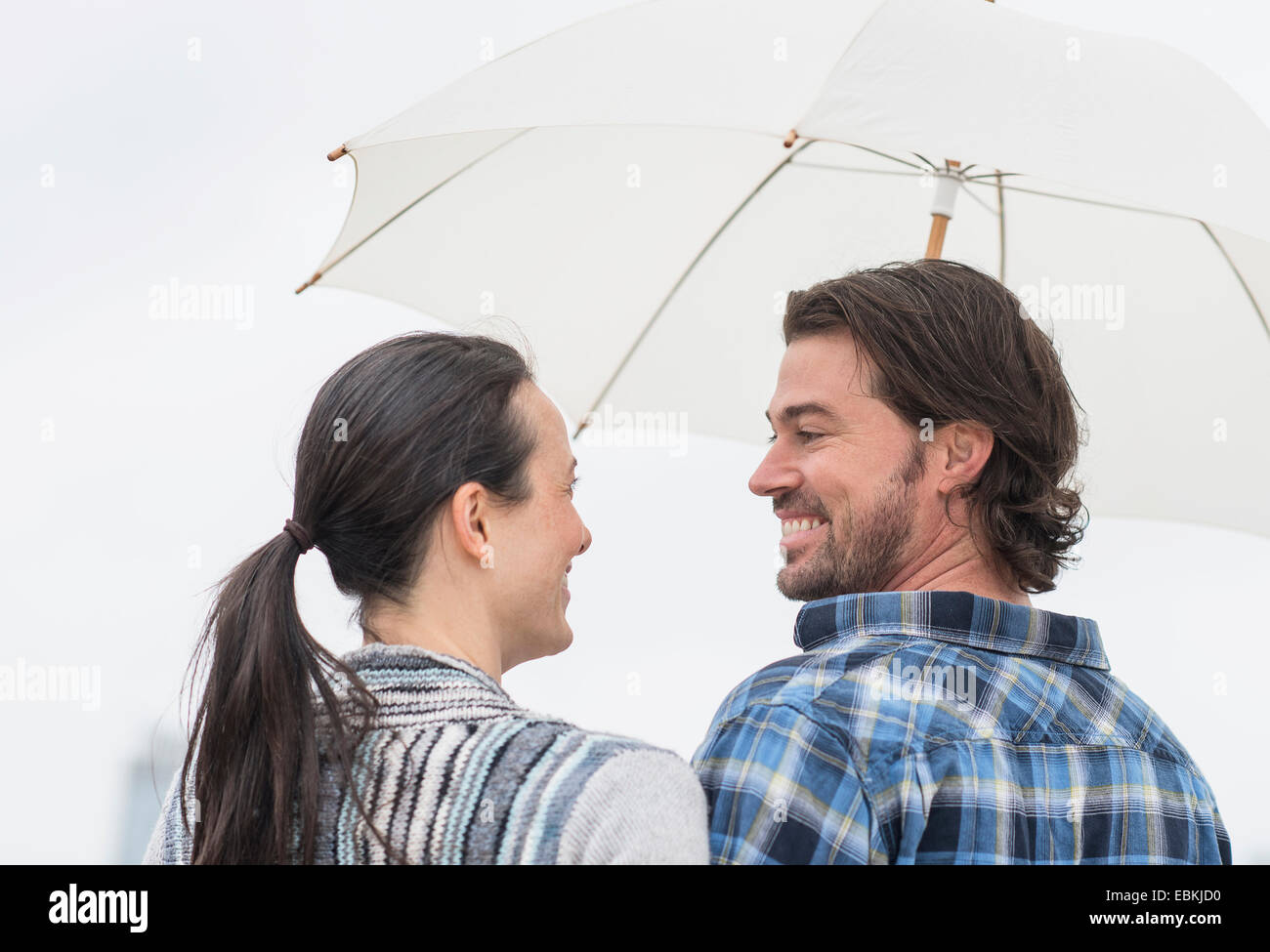 Rear view of couple under umbrella Stock Photo