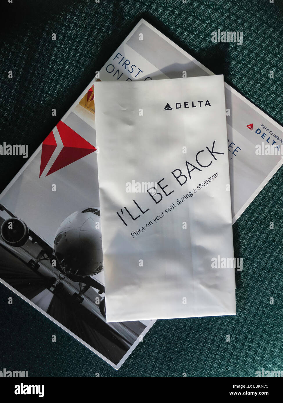 Delta Airlines Occupied Seat Marker, 'I'll Be Back' and Brochure on Airplane Seat , USA Stock Photo
