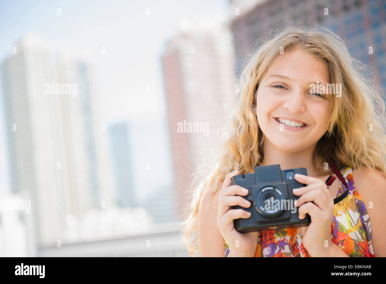 USA, New Jersey, Girl (12-13) holding camera, smiling Stock Photo