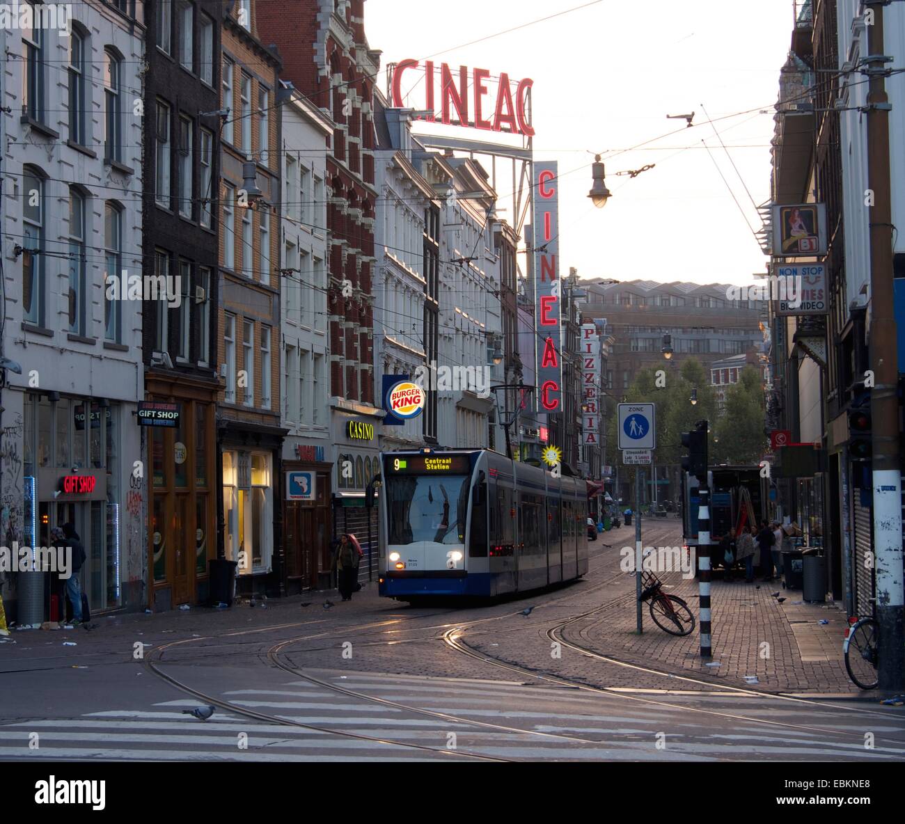Tram traveling through the streets of Amsterdam in the early morning light, showcasing urban life in the Netherlands Stock Photo