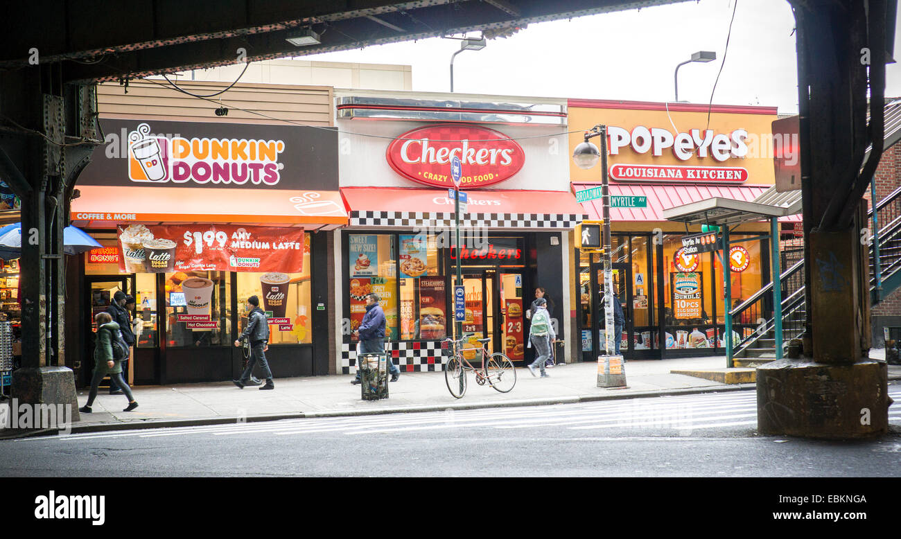 A collection of fast food businesses under the elevated train at the Myrtle Avenue stop in the Bushwick neighborhood of Brooklyn Stock Photo