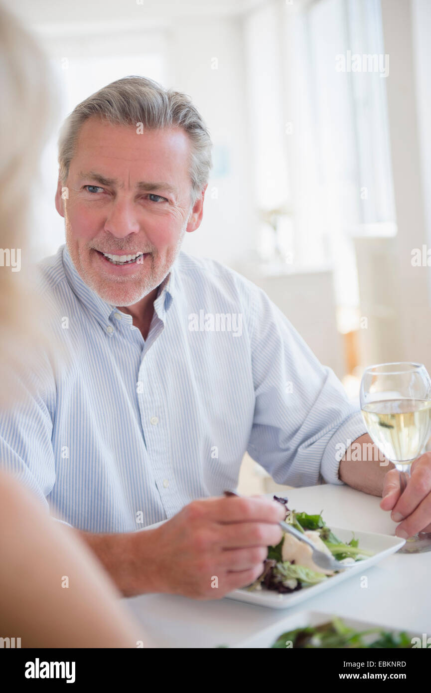 Portrait of man eating and drinking white wine at restaurant Stock Photo