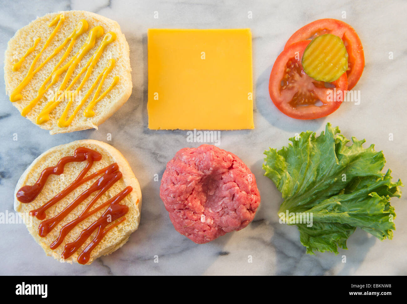Close-up shot of hamburger ingredients in rows on table Stock Photo