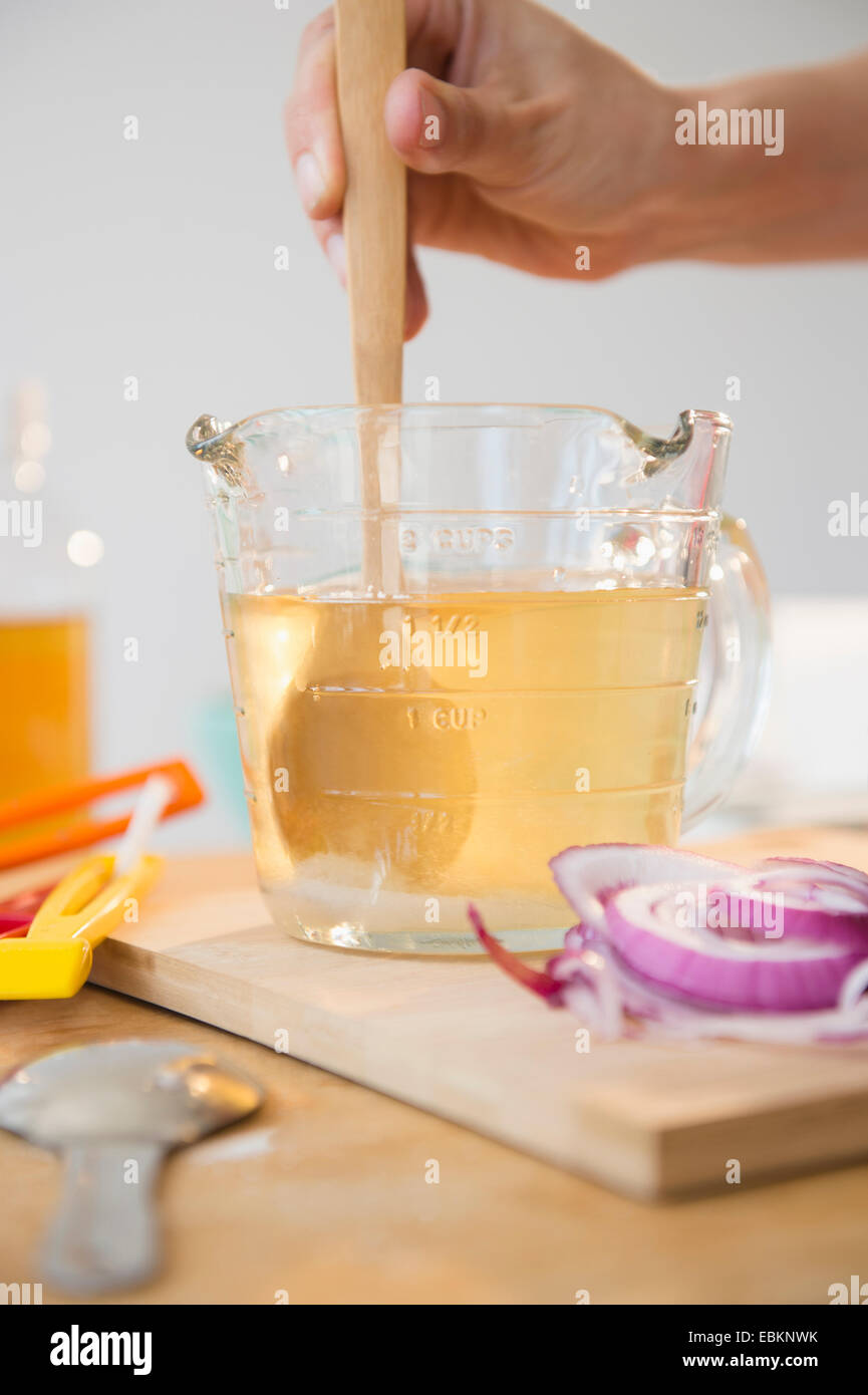 Studio shot of woman's hand stirring liquid in jug Stock Photo