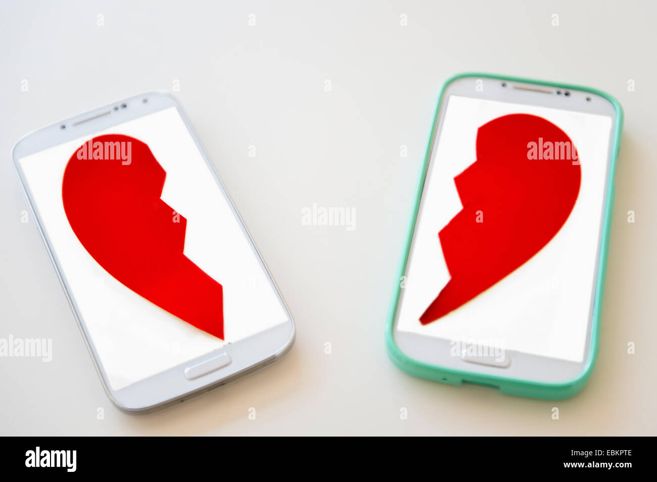 Studio shot of smart phones with broken heart on screen Stock Photo