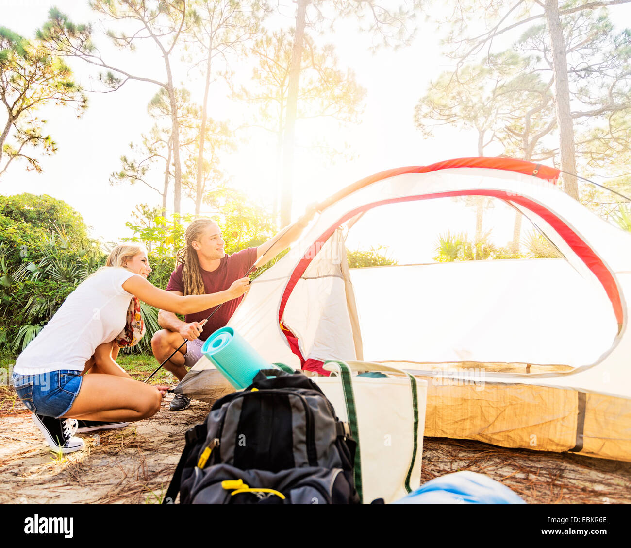 USA, Florida, Tequesta, Couple setting up tent in forest Stock Photo