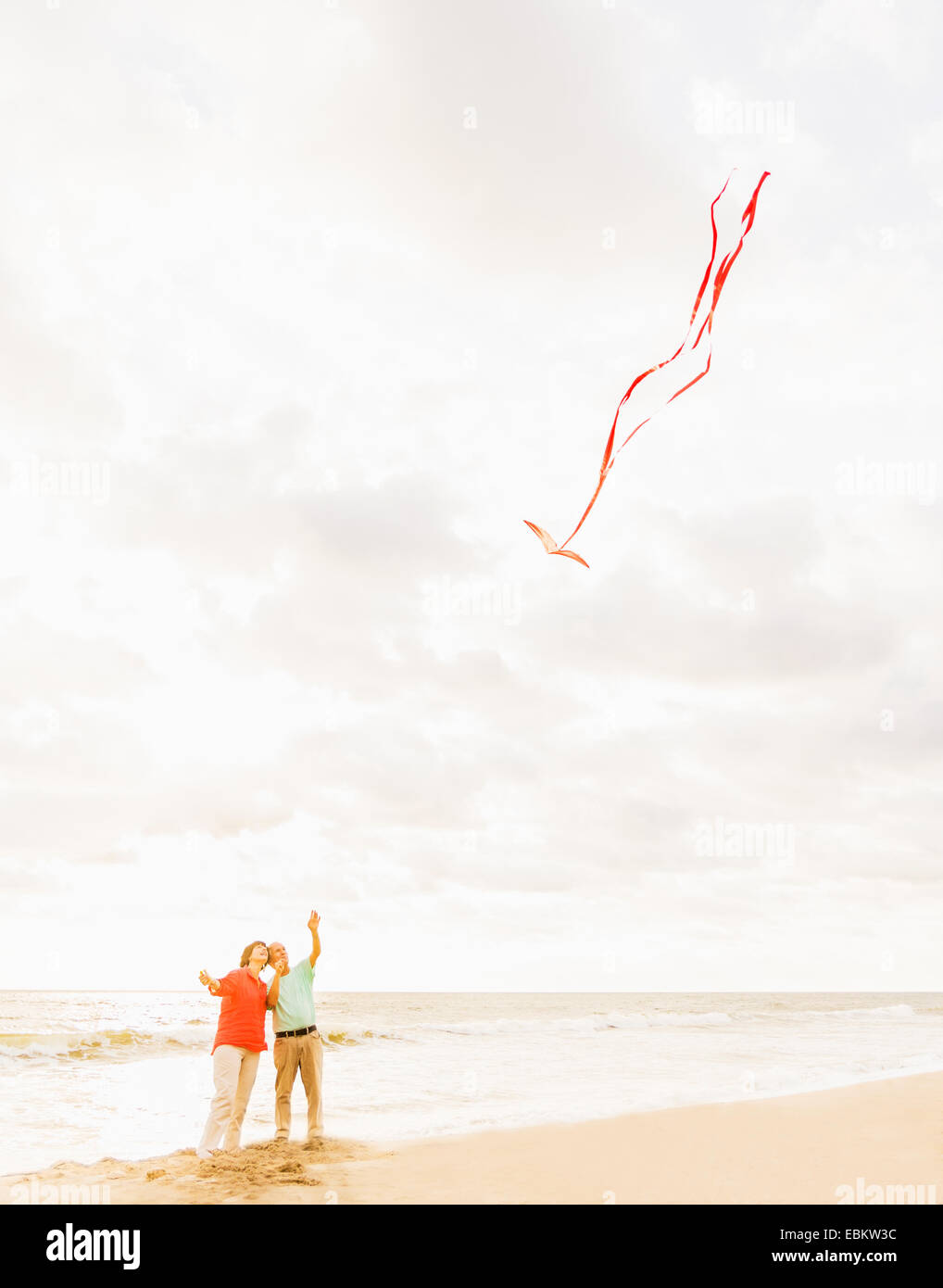 USA, Florida, Jupiter, Couple flying kite together on beach Stock Photo