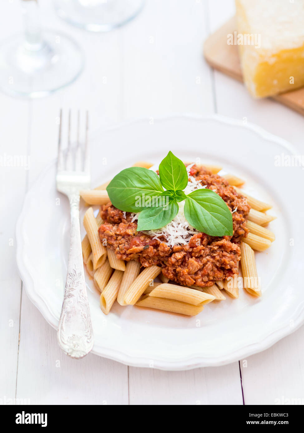 Whole grain penne pasta with vegetarian Bolognese sauce and Parmesan cheese Stock Photo