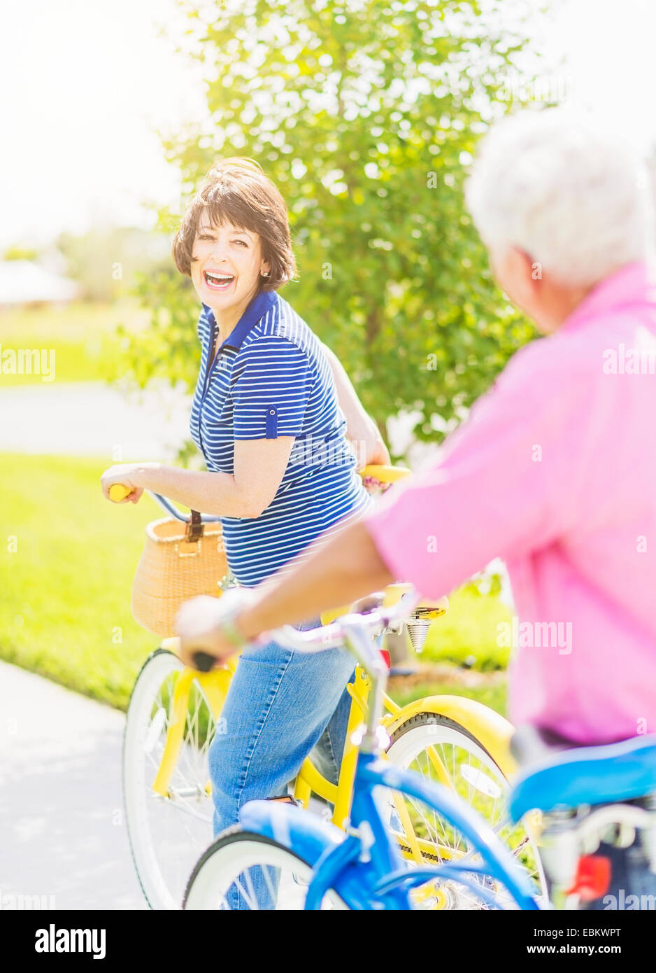 USA, Florida, Jupiter, Portrait of woman looking over shoulder at senior man, while getting on bicycle and laughing Stock Photo