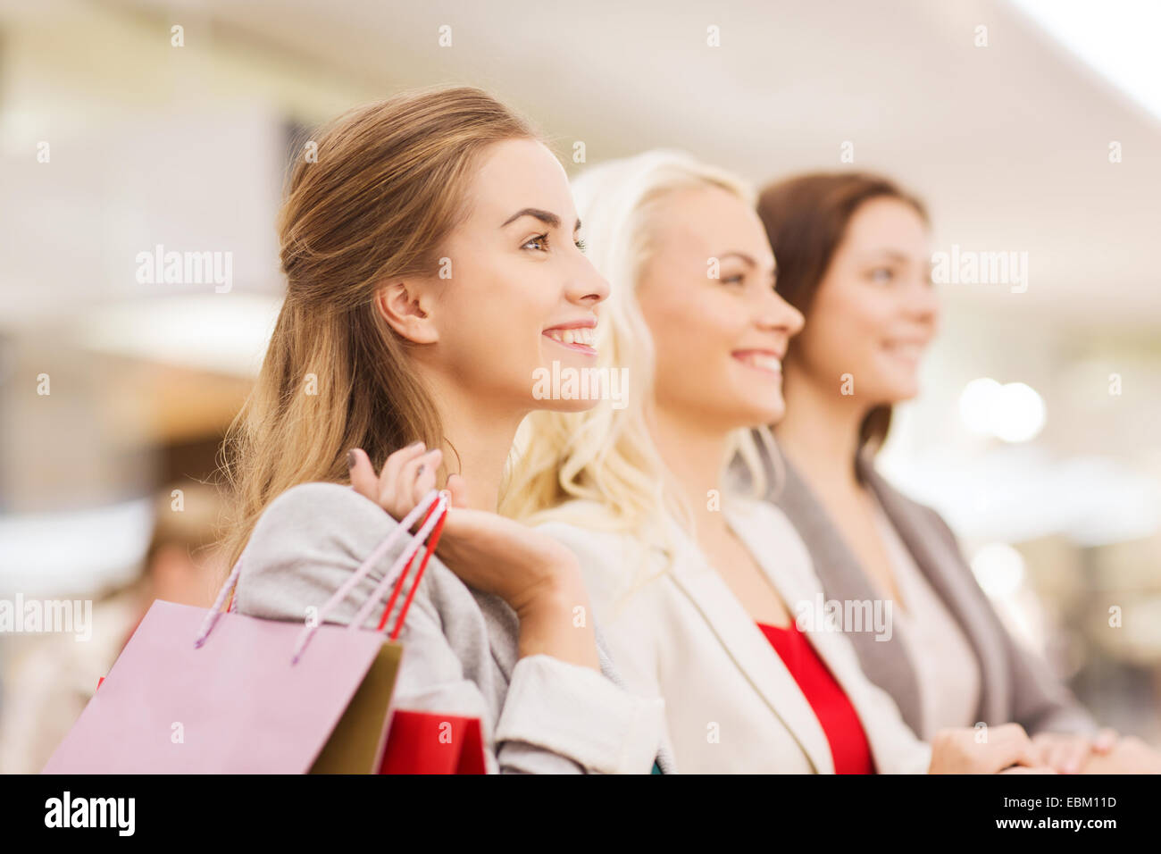 happy young women with shopping bags in mall Stock Photo - Alamy