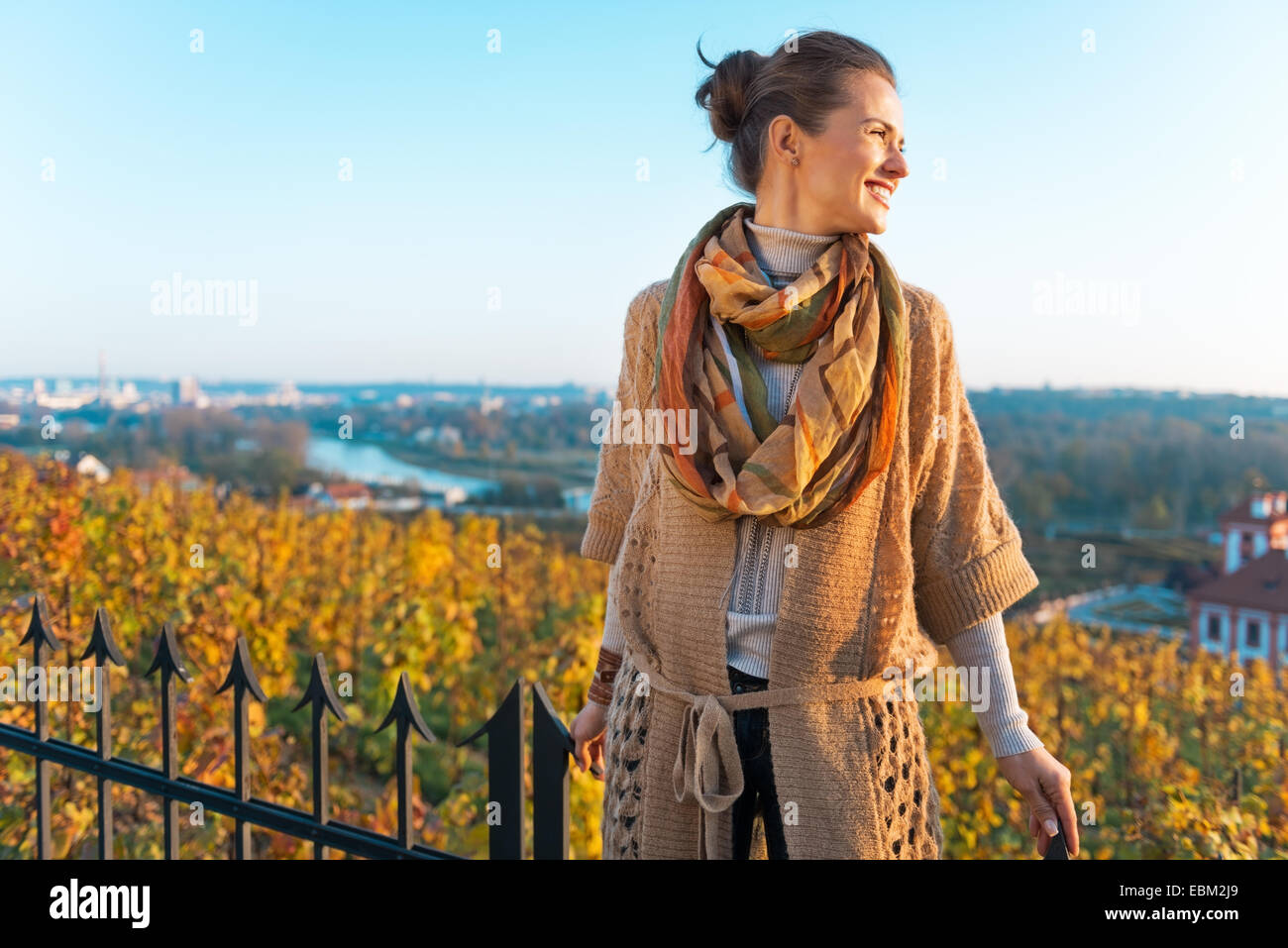 Happy young woman in autumn outdoors in evening Stock Photo