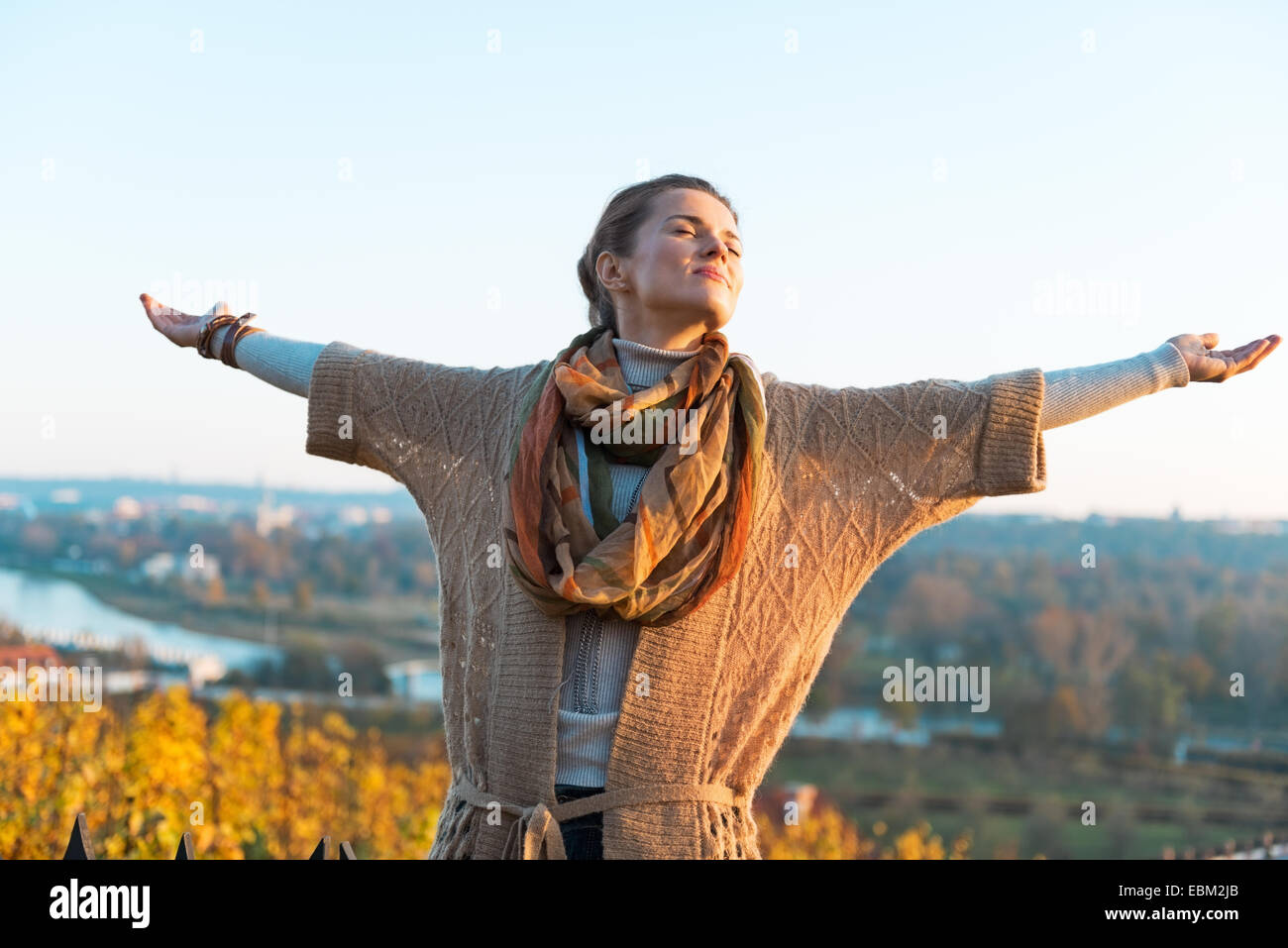 Happy young woman in autumn outdoors in evening rejoicing Stock Photo