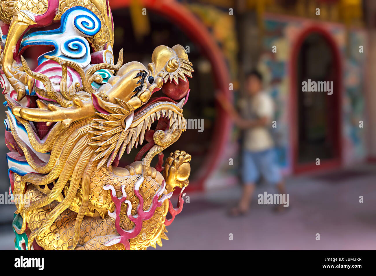 Gold painted dragon with man in background, Tua Pek Kong Chinese Temple, Miri, Sarawak, Malaysia Stock Photo