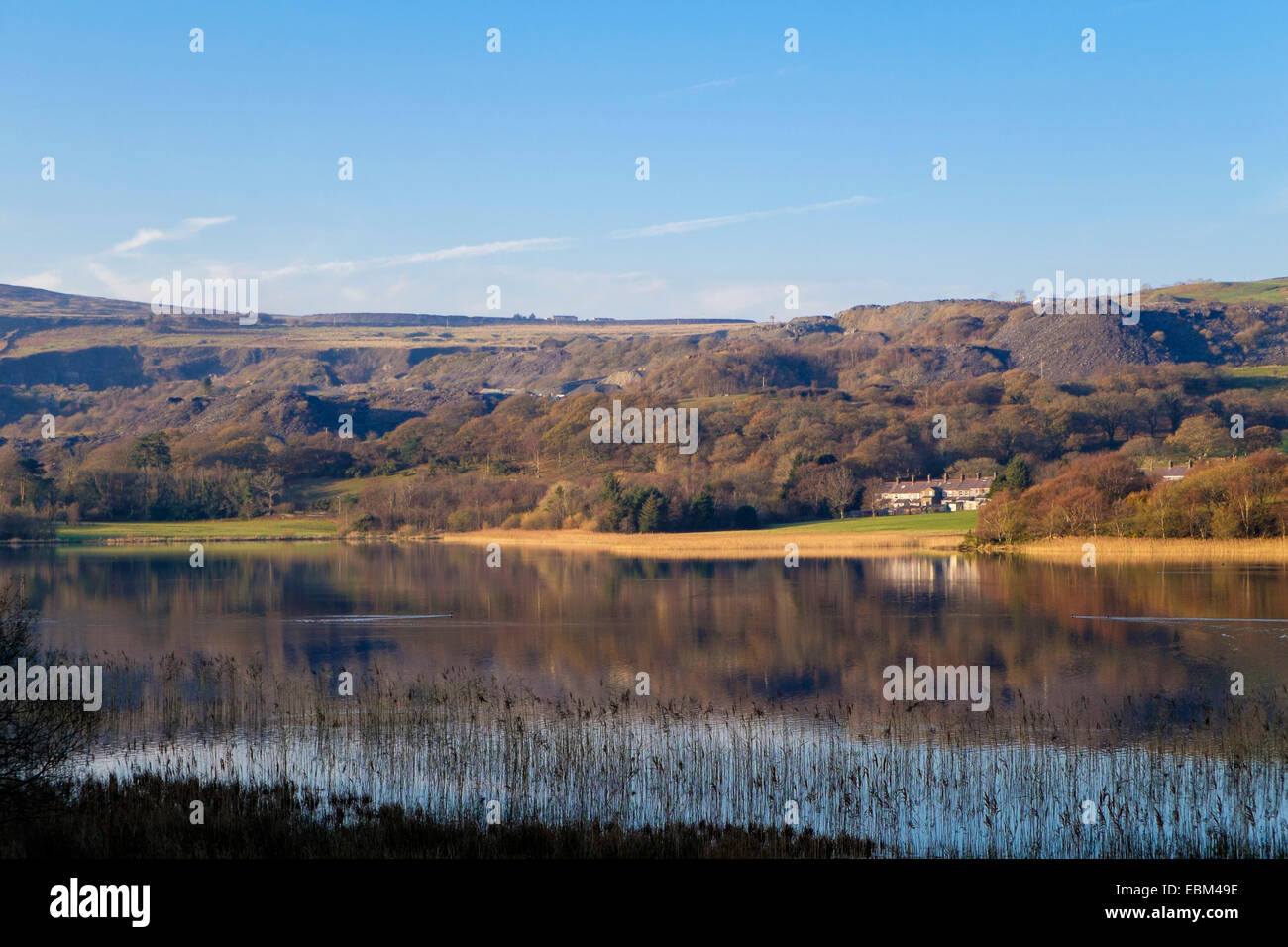 View across Llyn Nantlle Uchaf lake to village below slate quarry in ...