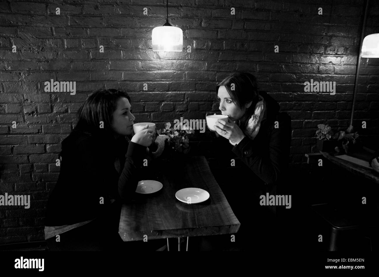Manhattan New York USA November 2014  - Two young women drink coffee in a Chelsea cafe  Photograph taken by Simon Dack Stock Photo