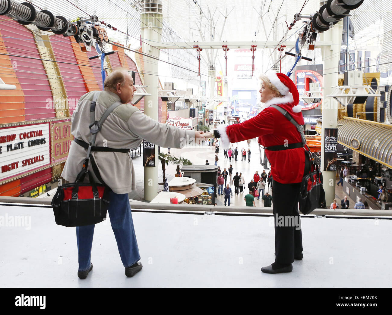 Las Vegas, NV, USA. 2nd Dec, 2014. Mayor of Las Vegas CAROLYN GOODMAN, right, and entertainment personality ROBIN LEACH hold hands after dashing down the larger-than-life SlotZilla zipline on Tuesday, Dec. 2, 2014 in Las Vegas. LEACH and GOODMAN challenged each other to ride SlotZilla in return for a $5,000 each donation to Las Vegas charity event, the Great Santa Run, taking place Saturday, December 6. Credit:  Bizuayehu Tesfaye/ZUMA Wire/ZUMAPRESS.com/Alamy Live News Stock Photo