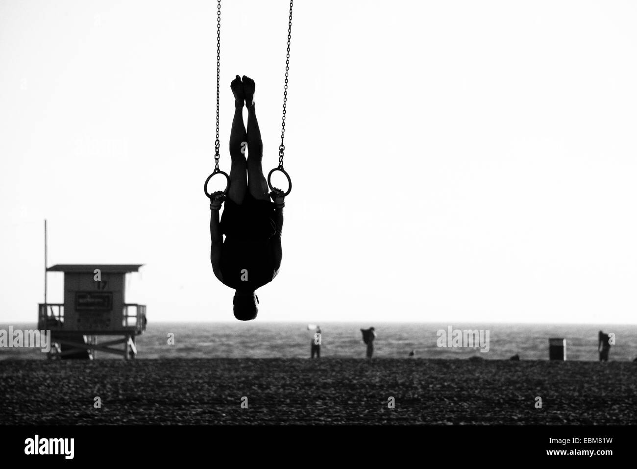 Silhouette of a person swinging on rings on the beach, Santa Monica Beach, Santa Monica, Los Angeles County, California, USA Stock Photo