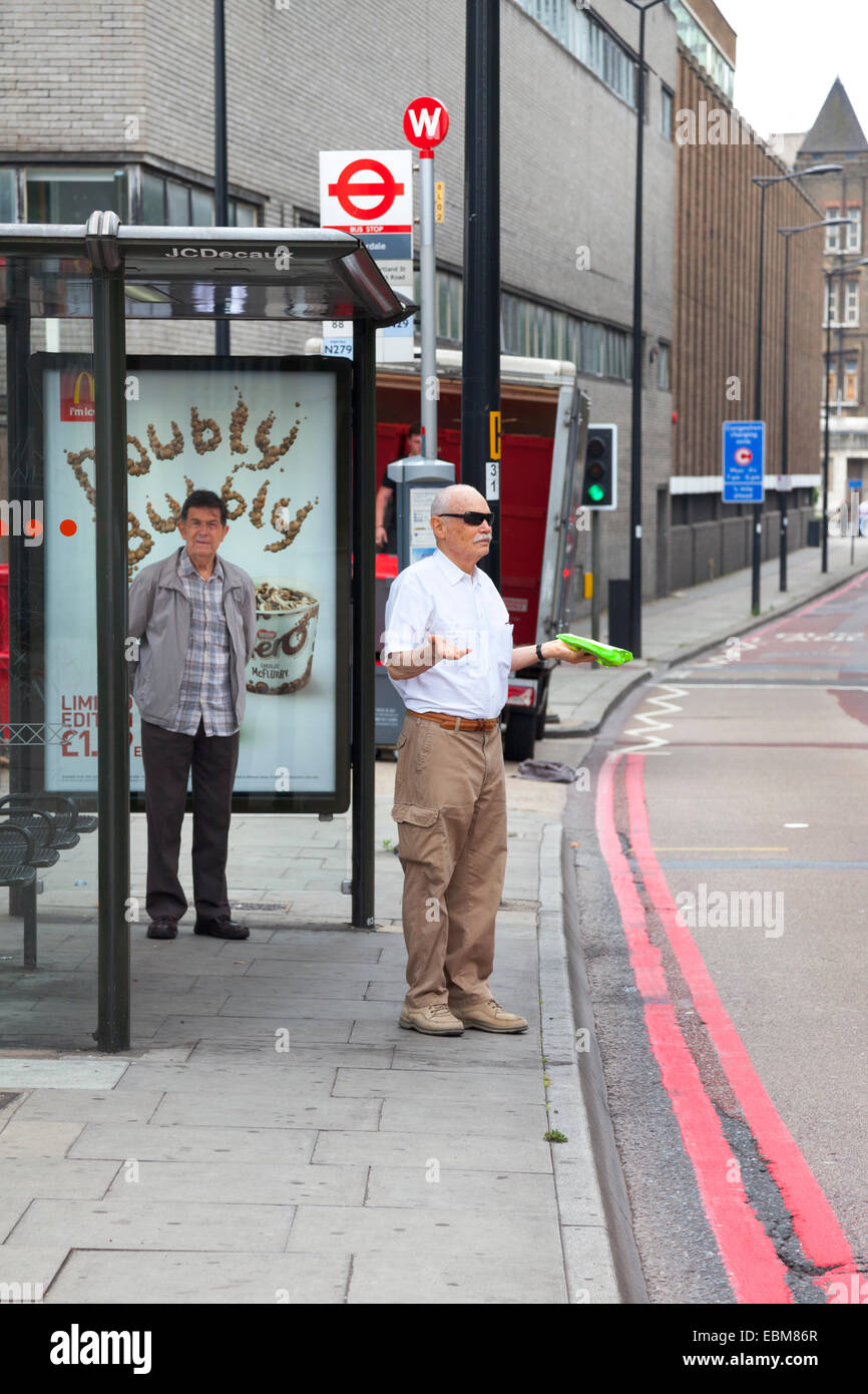 Where is the bus? - waiting at a bus stop in North London Stock Photo