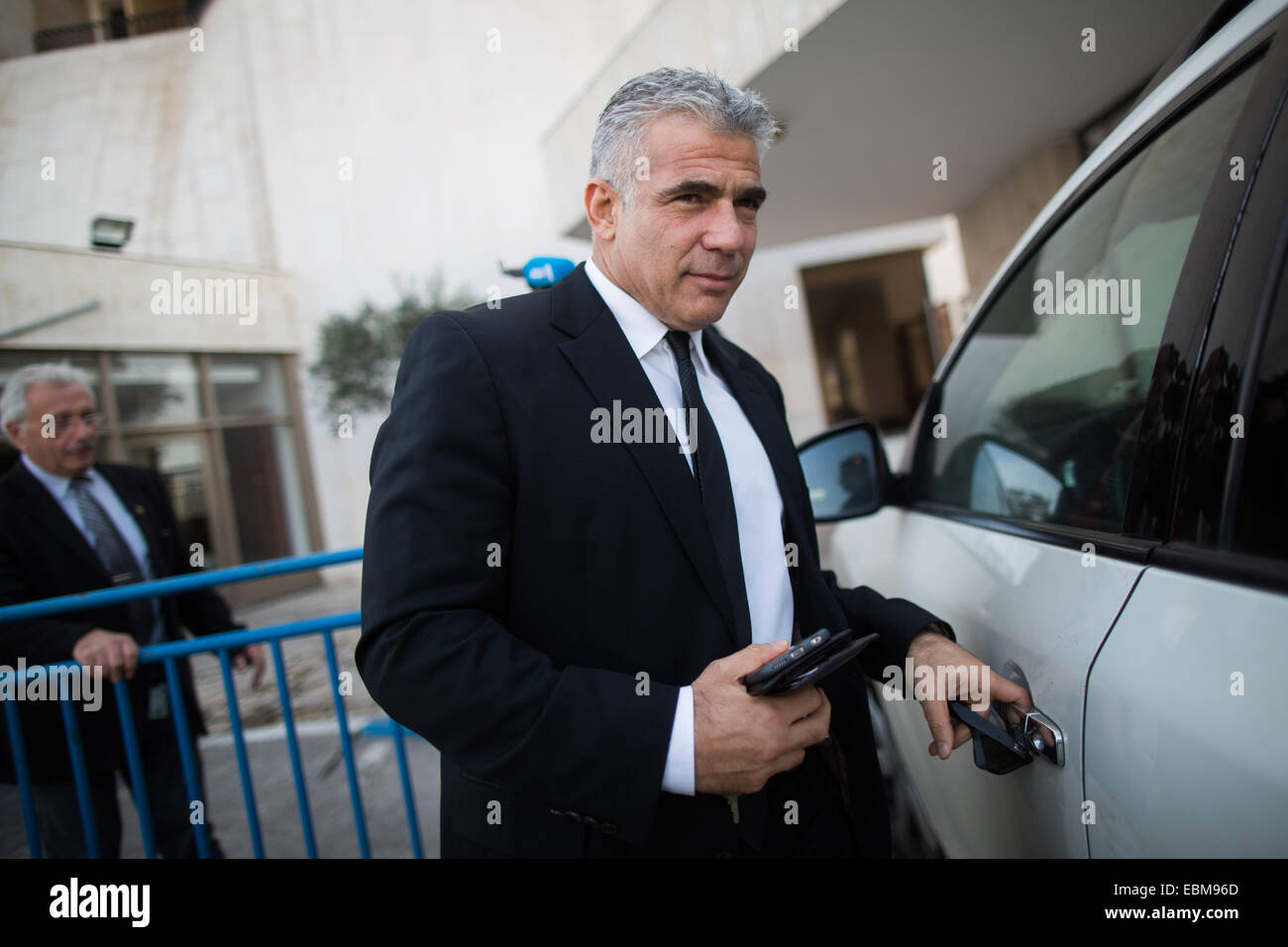 Jerusalem. 2nd Dec, 2014. Israeli Finance Minister Yair Lapid (front) leaves a financial conference in Jerusalem, on Dec. 2, 2014. Israeli Prime Minister Benjamin Netanyahu announced his support for dispersing the Knesset (parliament) and conducting early elections amid a coalition crisis. During a press conference at his Jerusalem office, Netanyahu also said he has ordered to fire Justice Minister Tzipi Livni and Finance Minister Yair Lapid, who he said plotted against him by outspokenly criticizing his policies. Credit:  JINI/Xinhua/Alamy Live News Stock Photo