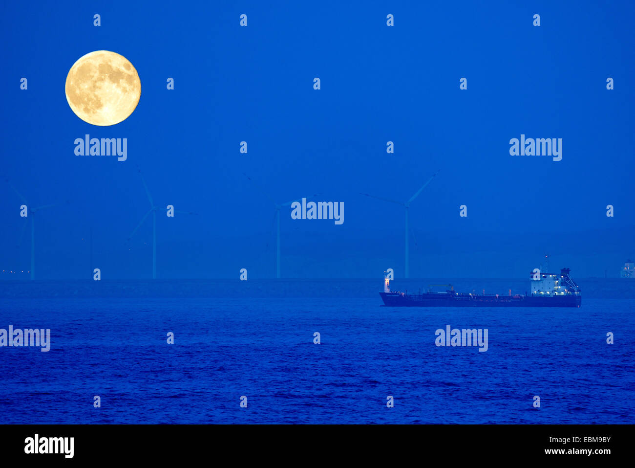 Cargo Ship under the big Moon Stock Photo