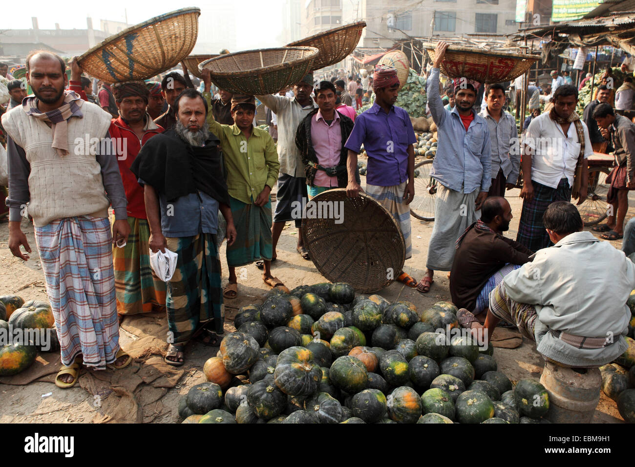 Men at the market at Gulshan in Dhaka, Bangladesh. Fruit and vegetables are sold wholesale at the market and carried by porters. Stock Photo