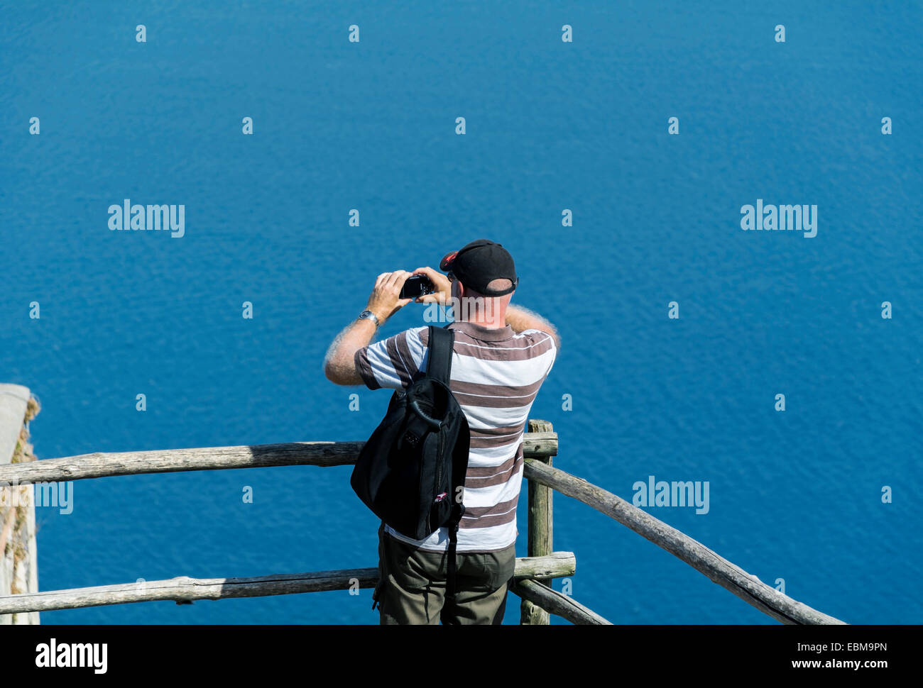 A man taking a photo of a sea view using a compact digital camera Stock ...