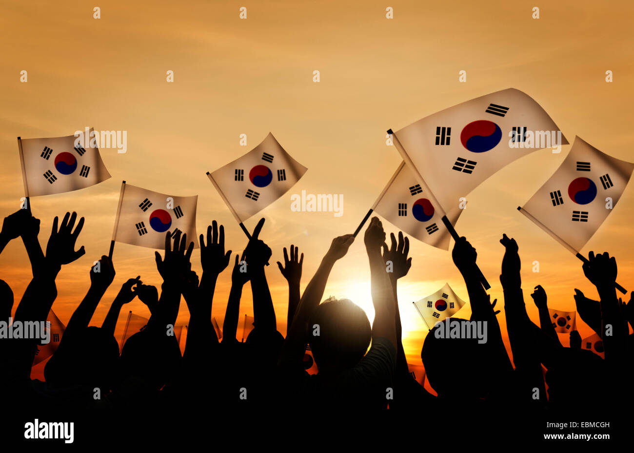Silhouettes of People Holding Flag of South Korea Stock Photo