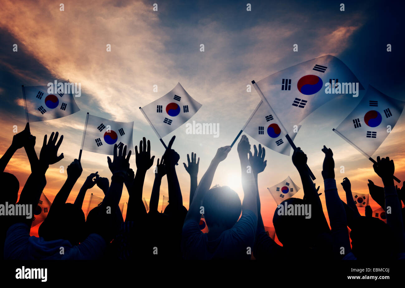 Silhouettes of People Holding Flag of South Korea Stock Photo