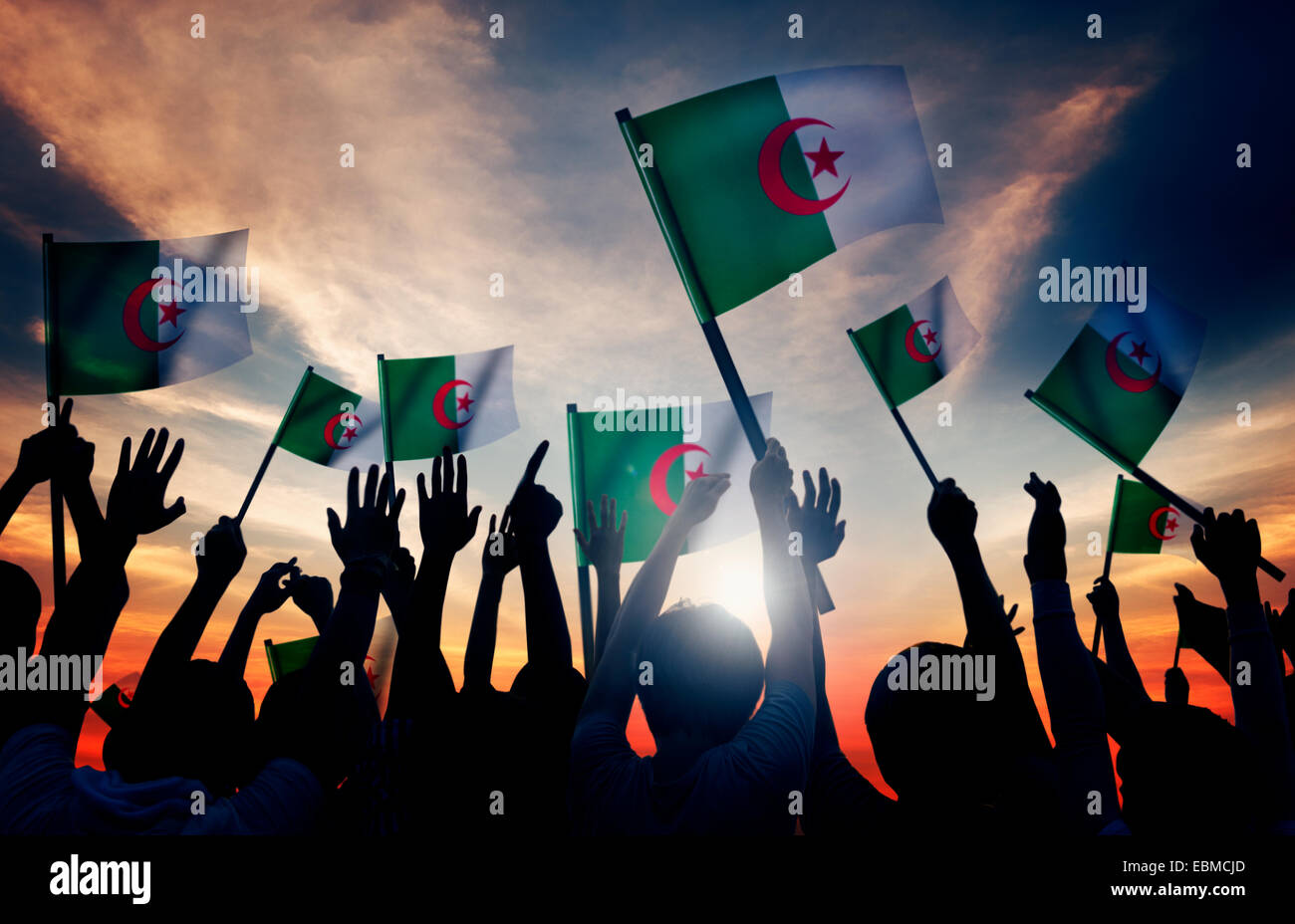Silhouettes of People Holding Flag of Algeria Stock Photo