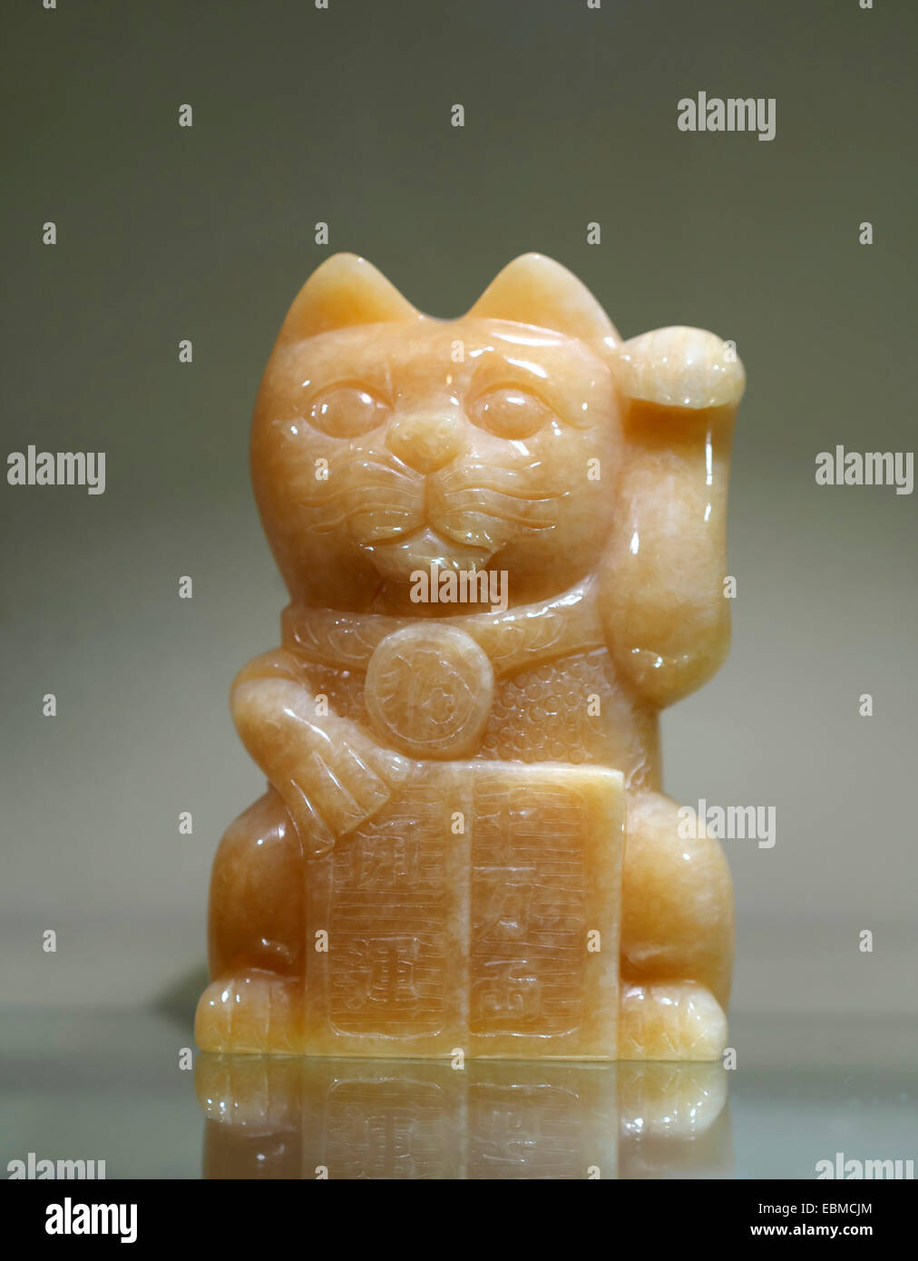 Maneki-neko (lucky waving fortune cat) jade sculpture Stock Photo