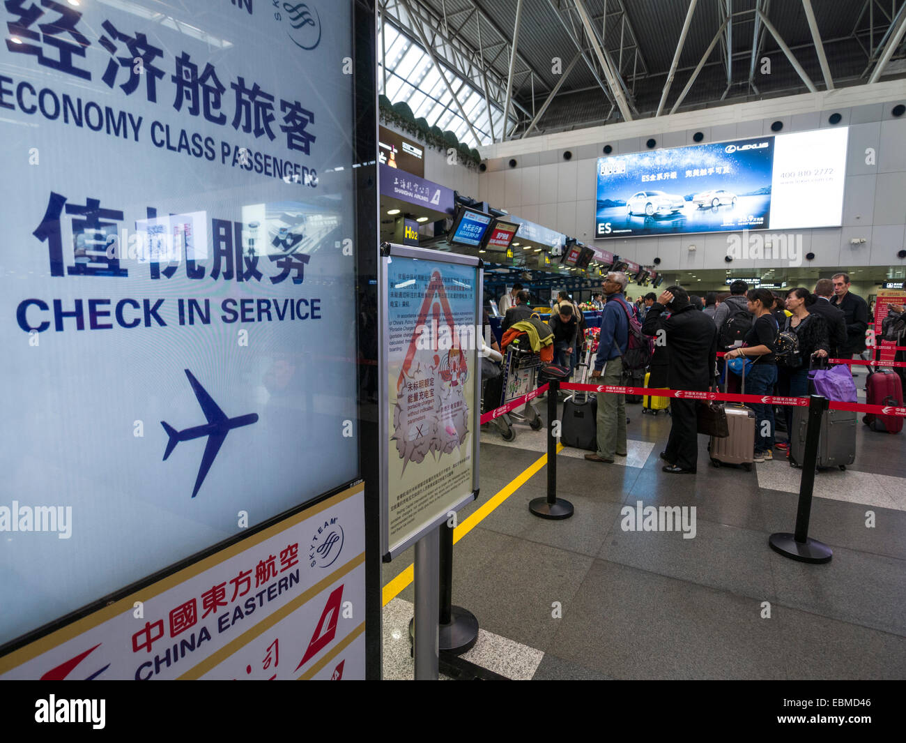 Passengers with luggage waiting in line at the check in counter at Beijing Capital International Airport, China Stock Photo