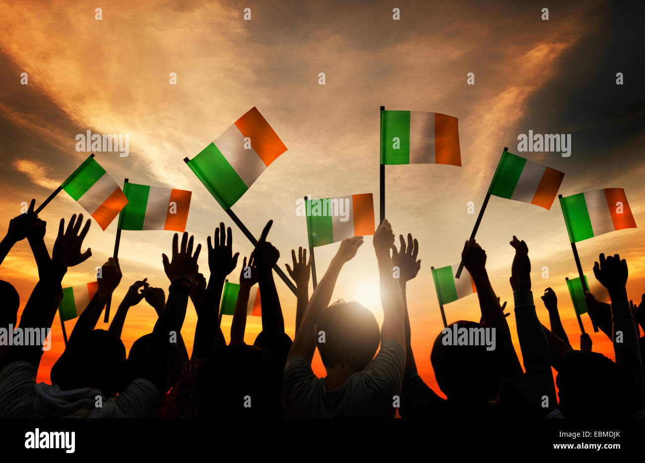 Silhouettes of People Waving the Flag of Ireland Stock Photo - Alamy