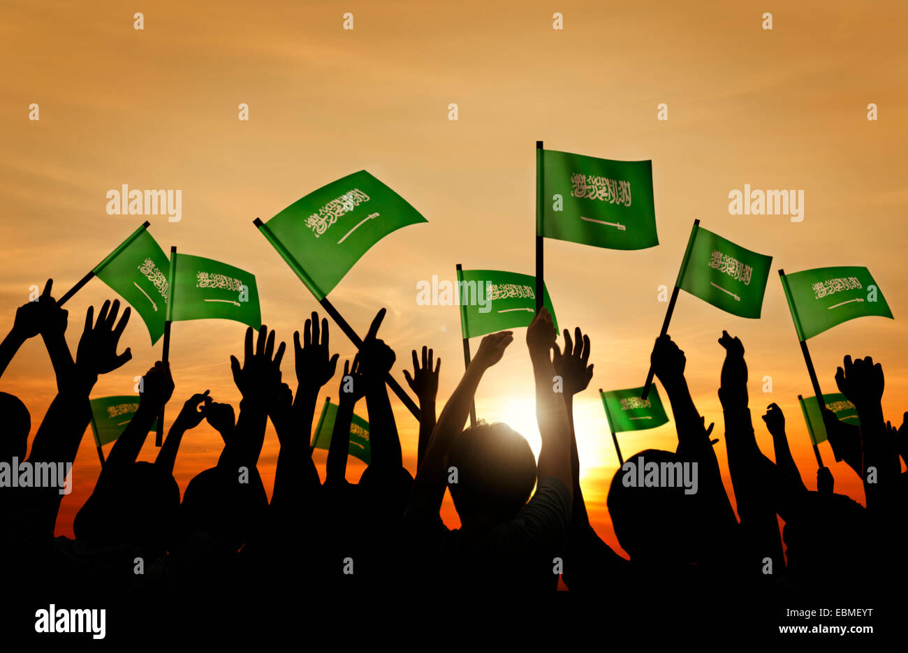 Silhouettes of People Holding Flag of Saudi Arabia Stock Photo