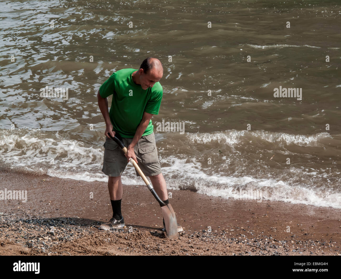 New York, NY 25 July 2009 Man cleaning up the beach beneath the