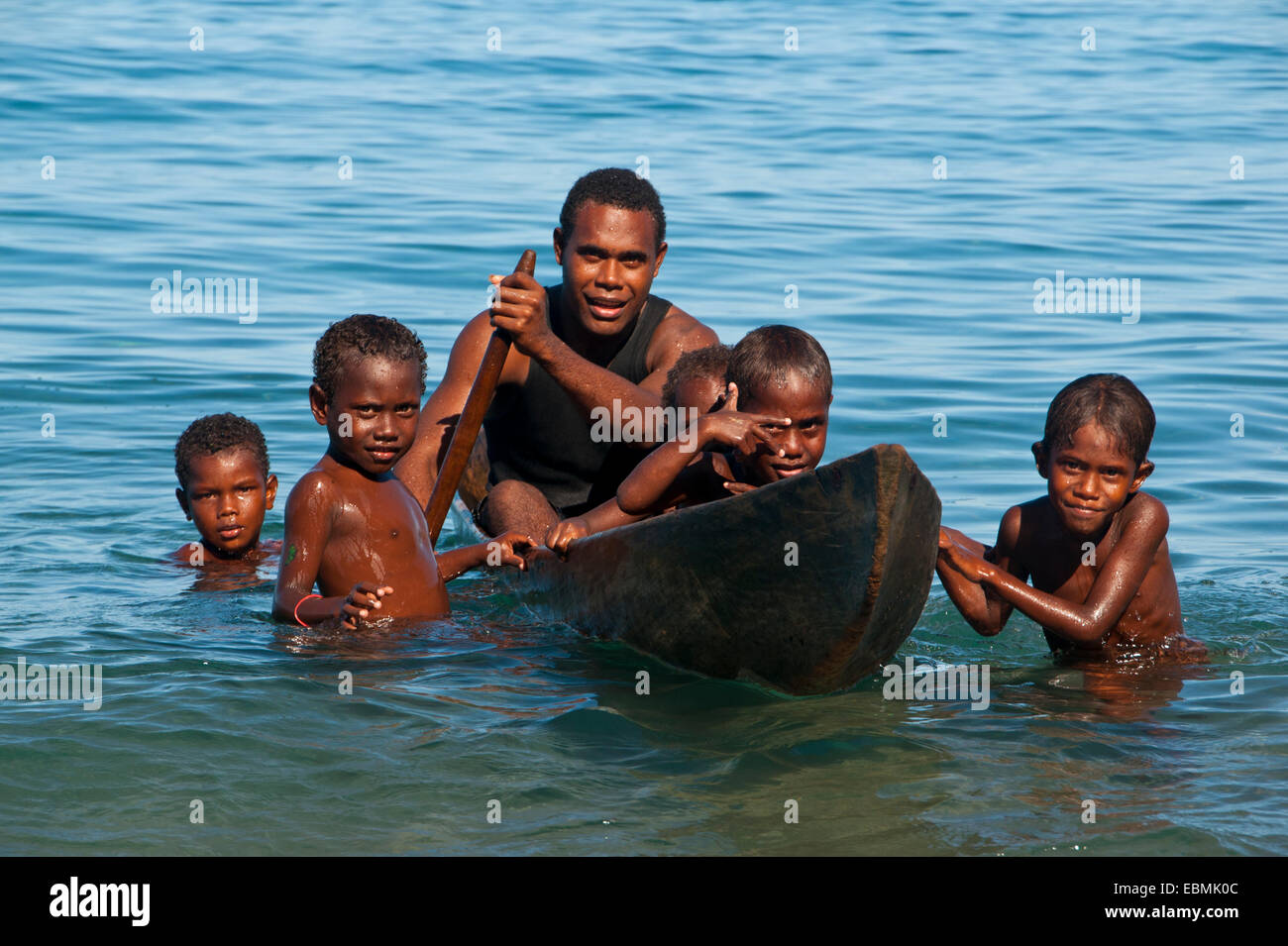 A man and children with a canoe, Savo Island, Central Province, Solomon Islands Stock Photo