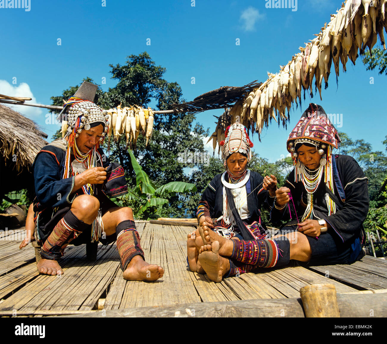 Akha women in a mountain village, in traditional costume and headdresses with silver coins, Chiang Rai Province Stock Photo
