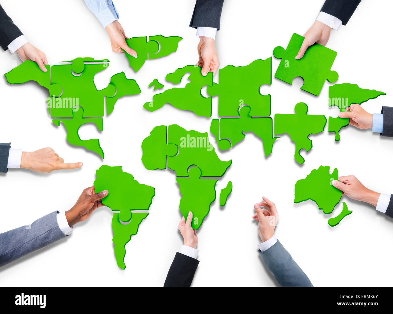 Group of Business People with Jigsaw Puzzle Forming in World Map Stock Photo