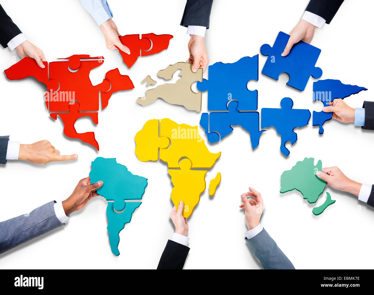 Group of Business People with Jigsaw Puzzle Forming in World Map Stock Photo