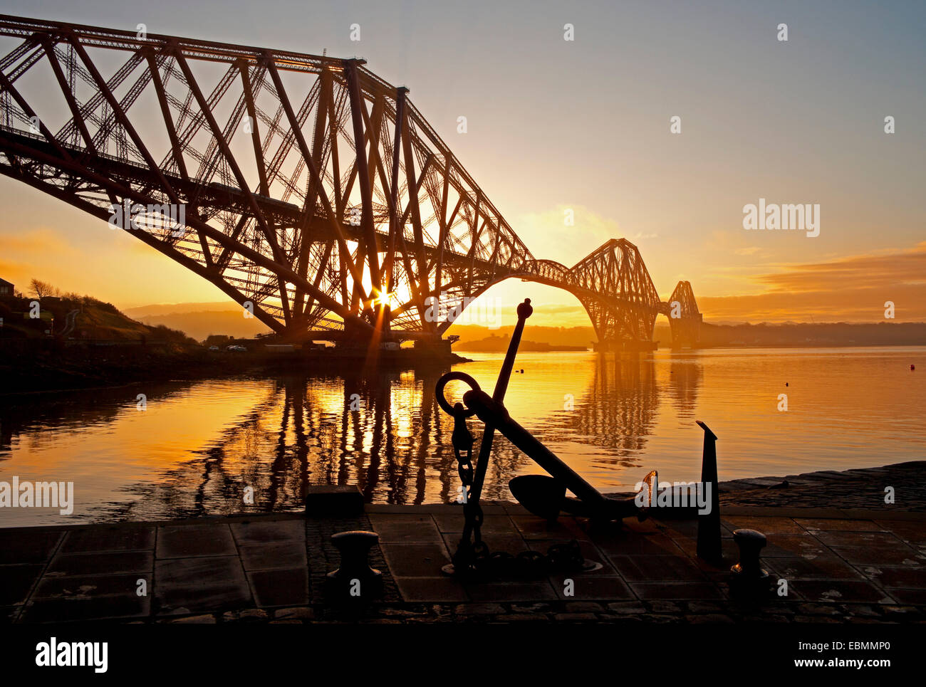 North Queensferry, Fife, Scotland, UK.  UK weather. Sunrise behind the Forth Rail Bridge on a cold morning with temperature at 3 degrees. Stock Photo