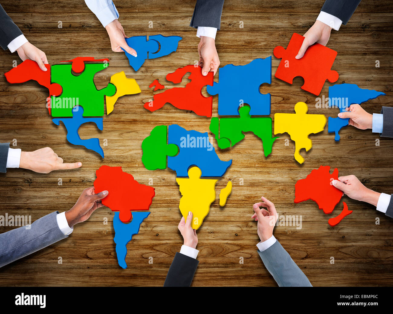 Aerial View of People Forming World Map with Puzzle Pieces Stock Photo