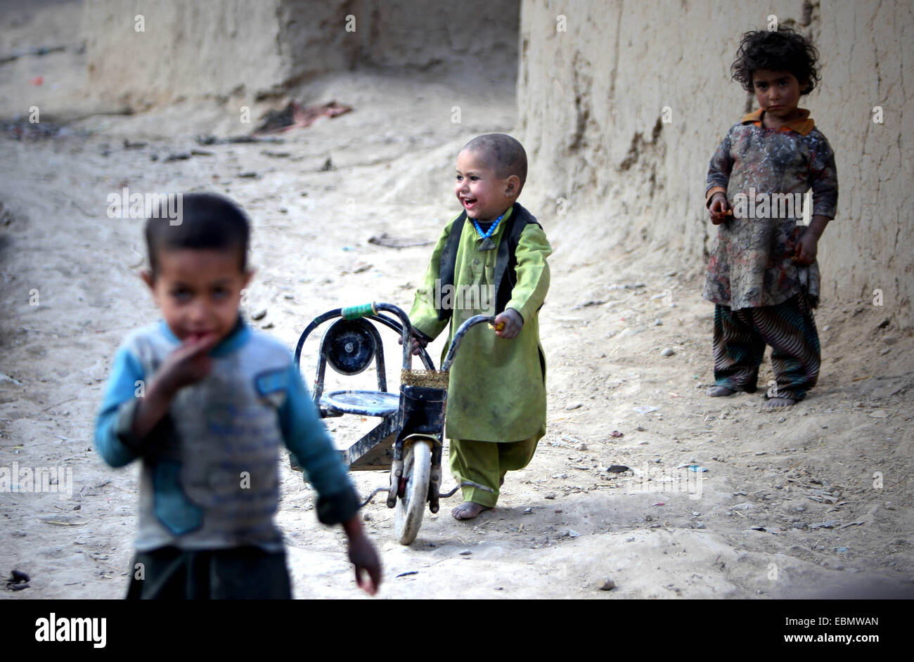 Kabul, Afghanistan. 2nd Dec, 2014. An Afghan displaced boy pushes his bicycle outside his home in Kabul, Afghanistan, Dec. 2, 2014. It is believed that nearly 4 million school-aged Afghan children are kept from schooling, according to officials. © Ahmad Massoud/Xinhua/Alamy Live News Stock Photo