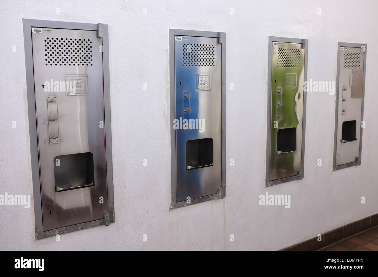 Hand washing and drying machines in a mens toilet Stock Photo