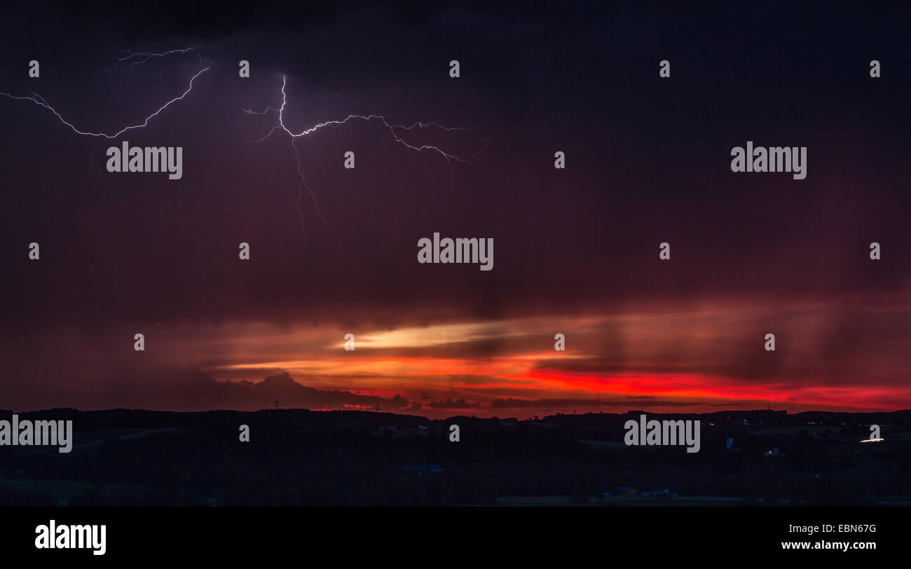 thunderstorm with lightning in front of red evening sky, Germany, Bavaria, Isental Stock Photo