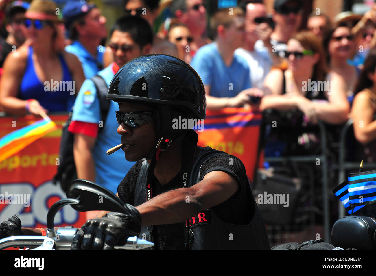 A woman rides a motorbike while smoking a cigar at the 2014 World Pride in Toronto. Stock Photo