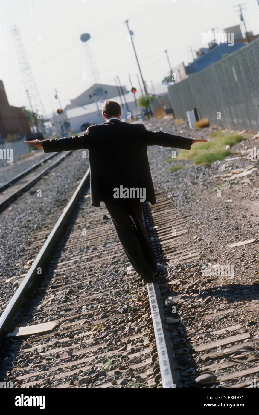Businessman walking on railroad track, Stock Photo