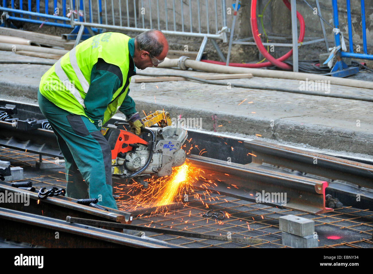 worker with abrasive cut-off machine working on tram lines, Czech ...